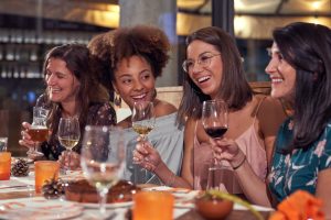Joyful diverse women with wineglasses