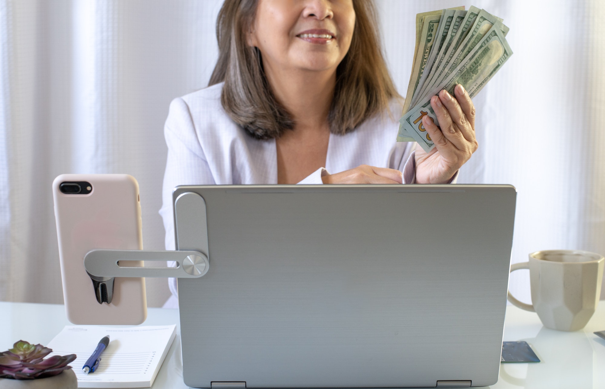 Woman holding money at her desk